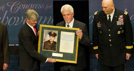Ray Kapaun displays the Medal of Honor citation and photo of his uncle, Chaplain (Capt.) Emil J. Kapaun as (from left) Secretary of Defense Chuck Hagel, Secretary of the Army John McHugh, Army Chief of Staff Gen. Raymond T. Odierno and Sgt. Maj. of the Army Raymond F. Chandler III looks on. (Photo Credit: U.S. Army)