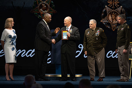Secretary of Defense Lloyd J. Austin III presents the Medal of Honor flag to retired Army Lt. Col. John D. Lock, accepting on behalf of Medal of Honor recipient Army 1st Lt. Ralph Puckett, Jr., in a ceremony in which Puckett and five other Medal of Honor recipients were inducted into the Pentagon Hall of Heroes, at Joint Base Myer-Henderson Hall, Va., July 6, 2022. (DoD photo by U.S. Navy Petty Officer 2nd Class Alexander Kubitza)
