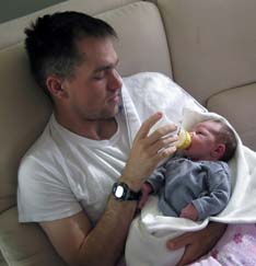 Clint Romesha feeds his one-week old daughter, Gwen, in early 2009.