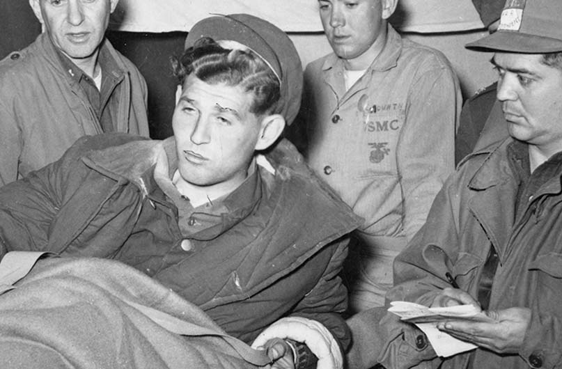 Rubin, lying down with a blanket over him, talks to reporters upon his release from the Communist prisoner of war camp. Although life in the camp was difficult, he told reporters from Stars and Stripes that the Chinese treated him much better than the Germans had. Photo used with permission from Stars and Stripes