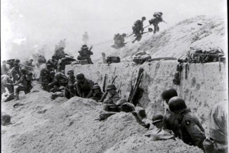 Soldiers move over a seawall on Utah Beach during the Allied Invasion of Europe.