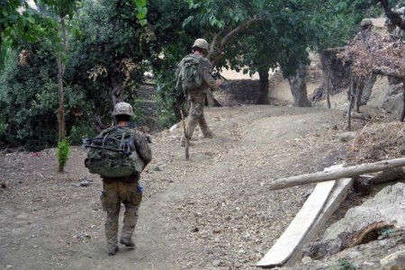 Soldiers walking up hill with their backpacks on