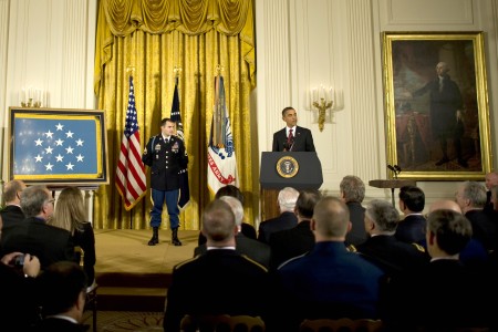 President Barack Obama standing on stage with Staff Sergeant Salcatore Giunta