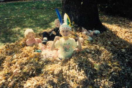 Children playing ina leaf pile
