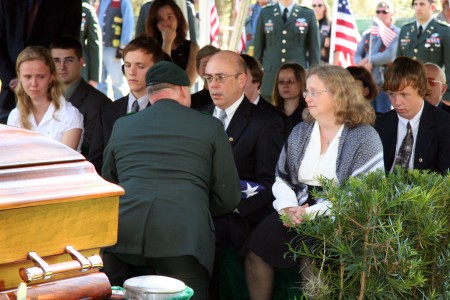 Soldier handing American flag to Staff Sergeant Robert Miller's family