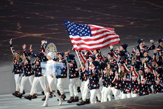 Todd Lodwick carries the flag of the United States of America, which flies directly over the head of former U.S. Army World Class Athlete Program bobsledder Steven Holcomb, reigning Olympic champion four-man bobsled driver, as Team USA marches into Fisht Olympic Stadium during the Opening Ceremony of the 2014 Olympic Winter Games, Feb. 7, 2014, in Sochi, Russia. Army WCAP luger Sgt. Preston Griffall (right behind lady in white) and WCAP bobsledders Sgt. Justin Olsen, Capt. Chris Fogt and Sgt. Dallas Robinson also are among the lead group of Americans (Photo Credit: Tim Hipps, IMCOM Public Affairs)