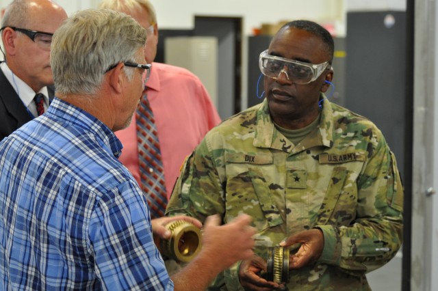 Brig. Gen. Richard Dix, commanding general of the Joint Munitions Command, is briefed by a Crane Army employee during his tour of the machine shop on CAAA's operations and missions toward supporting the Joint Warfighter. Dix also toured the pyrotechnic facility during his visit to get a firsthand look at Crane Army's missions, capabilities, and workforce structure. 