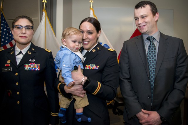 Iowa National Guard Maj. Jill Finkel (left) poses with her sister Massachusetts Army National Guard's newly promoted Maj. Molly Alesch (middle), her son and husband, at a promotion ceremony at Hanscom Air Force Base March 17.