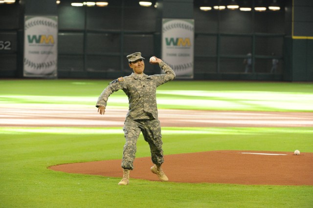 Lt. Col. Tanya Trout throws out the first pitch at start of the Houston Astros game July 18, 2015.  Just prior to the pitch, Trout and members of the 136th Expeditionary Signal Battalion conducted a deployment ceremony at the ballpark, casing their colors.  