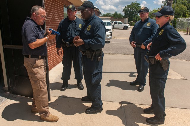 Phil McCombs, instructor, left, provides feedback to students following a building-clearing exercise July 11, 2017 at the U.S. Army Civilian Police Academy at Fort Leonard Wood, Missouri.