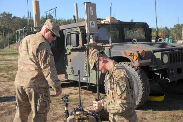 U.S. Army Staff Sgt. Christopher Morvant and U.S. Army Staff Sgt. Michael Deremain, electronic warfare specialists assigned to Headquarters and Headquarters Company, 1st Armored Brigade Combat Team, 1st Cavalry Division, prepare their VROD/VMAX backpack system for training at Zagan, Poland, Oct. 11, 2018. 