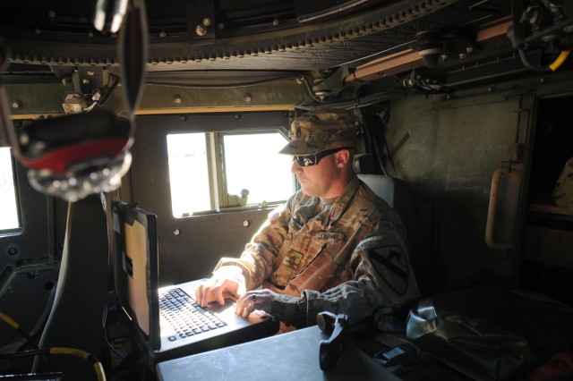 U.S. Army Staff Sgt. Christopher Morvant, an electronic warfare specialist assigned to Headquarters and Headquarters Company, 1st Armored Brigade Combat Team, 1st Cavalry Division, works on the Raven Claw computer and Humvee system during training at Zagan, Poland, Oct. 11, 2018. 