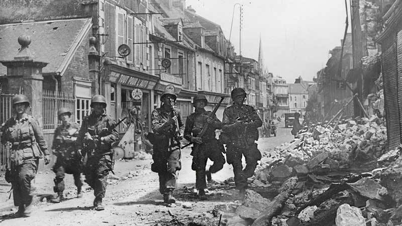 Paratroopers cautiously move through Carentan. Photo courtesy US Army Signal Corps.