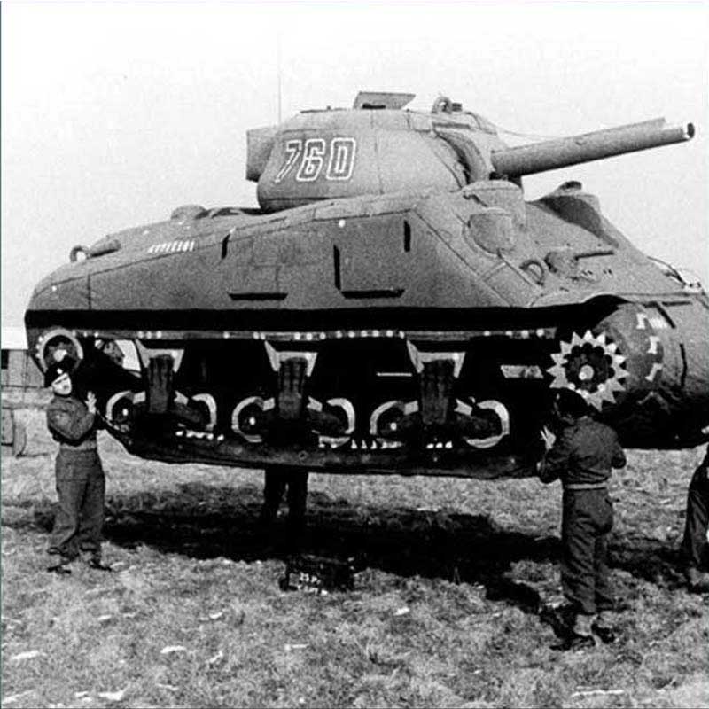 Soldiers from the 23rd Headquarters Special Troops lift a rubber tank as part of an invasion deception.