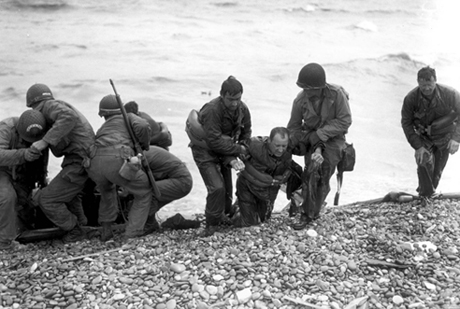 Survivors of downed landing craft reach Omaha Beach by using a life raft, June 6, 1944.