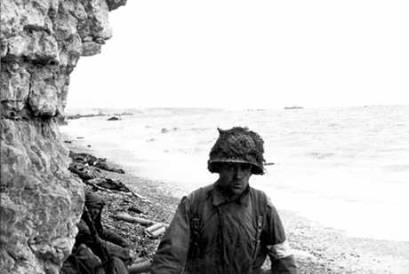 Medic administering first aid to men wounded in the landing.