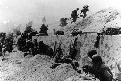 U.S. Soldiers of the 8th Infantry Regiment, 4th Infantry Division, move over a seawall on Utah Beach.