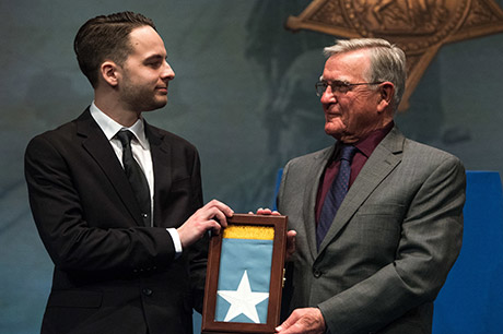 Mr. David L. Norquist, performing the duties of the U.S. deputy secretary of defense, presents the Medal of Honor Flag to U.S. Army Sgt. Travis Atkins’ son, Trevor Oliver during a ceremony with Atkins' family at the Pentagon in Washington, D.C., March 28, 2019. The induction will add Atkins' name to the in the Hall of Heroes, the Department of Defense's permanent display of record for all recipients of the Medal of Honor. (DoD photo by U.S. Army Sgt. Amber I. Smith)