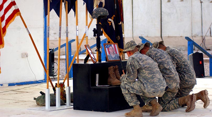 Soldiers kneel to pay their respects to Staff Sgt. Travis Atkins, who was killed, June 1, 2007, by a suicide
                                        bomber near Sadr Al-Yusufiyah, Iraq, at a memorial ceremony held, June 7, 2007 at Camp Striker. Atkins was on a patrol
                                        with his unit, Company D, 2nd Battalion, 14th Infantry Regiment, 2nd Brigade Combat Team, 10th Mountain Division (Light
                                        Infantry) from Fort Drum, N.Y., when they detained men who were wearing suicide vests. (U.S. Army photo by Spc. Chris
                                        McCann)