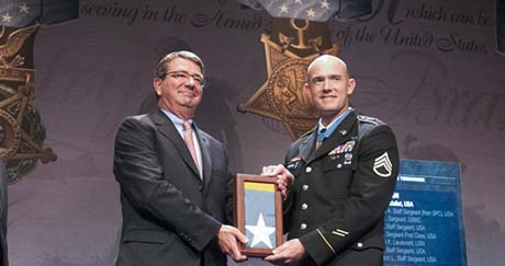 Staff Sgt. Ty Michael Carter being presented with the Medal of Honor Flag by Deputy Secretary of Defense Ashton B. Carter during his induction ceremony into the Hall of Heroes at the Pentagon, Aug. 27, 2013. From left to right stand Under Secretary Westphal, Deputy Secretary of Defense Ashton B. Carter, Staff Sgt. Ty Carter and wife Shannon Carter. U.S. Army photo by Staff Sgt. Bernardo Fuller.