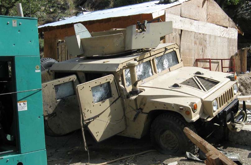 View of one of the pockmarked armored Humvees at COP Keating. The men at LRAS-2 were busy firing their .50 cal. when an RPG round knocked the heavy machine gun off its mount and wounding Sergeant Vernon Martin seriously. Specialist Ty Carter ran 75 yards through a shower of bullets to reach the Humvee with more M240 ammunition, but that gun was no longer operational. U.S. Army photo.