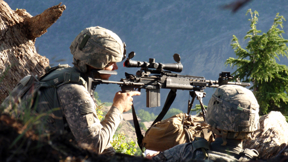 Spc. Ty Carter and Spc. Jonathan Adams, the Blue Platoon forward observer, look at the village of Kamdesh, Afghanistan, while on their first patrol out of Observation Point Fritsche, May 2009.