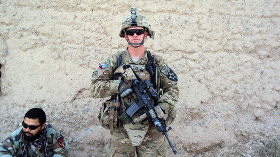 Staff Sgt. Ty Carter, with A Troop, 8-1 Cavalry, 2nd Stryker Brigade Combat Team, 2nd Infantry Division, stands guard at a hasty traffic control point in West Kandahar City, Afghanistan, sometime between May and July 2012.