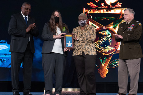 Secretary of Defense Lloyd J. Austin III and Chairman of the Joint Chiefs of Staff U.S. Army Gen. Mark A. Milley present the Medal of Honor flag to Tamara Cashe, the spouse of U.S. Army Sgt. 1st Class Alwyn C. Cashe, and Kasinal Cashe White, the sister of Sgt. 1st Class Cashe, during a Medal of Honor Induction Ceremony at Joint Base Myer-Henderson Hall, Va., Dec. 17, 2021. Sgt. 1st Class Cashe was posthumously awarded the Medal of Honor for actions of valor during Operation Iraqi Freedom while serving as a platoon sergeant with Alpha Company, 1st Battalion, 15th Infantry Regiment, 3rd Infantry Division, in Salah Ad Din province, Iraq, on Oct. 17, 2005. (U.S. Army photo by Laura Buchta)