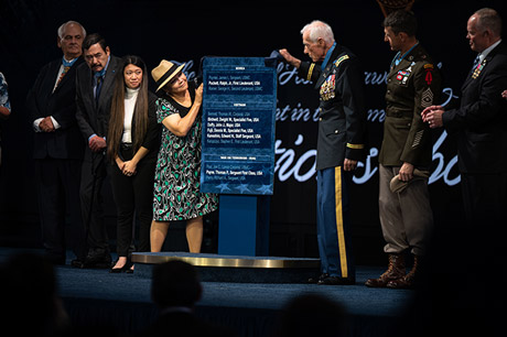 Mrs. Ashley Aczon-Skjelstad, the daughter of the late Medal of Honor recipient Army Staff Sgt. Edward N. Kaneshiro, unveils the plaque to be hung in Pentagon Hall of Heroes, after Kaneshiro and five other Medal of Honor recipients were inducted in the Hall of Heroes, at Joint Base Myer-Henderson Hall, Va., July 6, 2022. (DoD photo by U.S. Navy Petty Officer 2nd Class Alexander Kubitza)