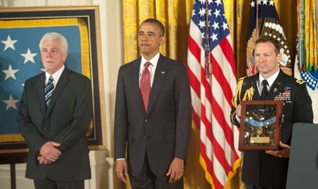 President Barack Obama and Ray Kapaun (left), nephew of Chaplain (Capt.) Emil J. Kapaun, who was posthumously awarded the Medal of Honor during a ceremony in the East Room of the White House, Washington, D.C., April 11, 2013, stand during the reading of the citation. (Photo Credit: U.S. Army)