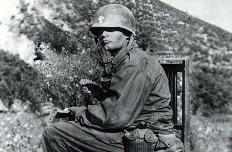 Army Chaplain Emil Kapaun writes a letter in Korea circa 1950. Kapaun spent countless hours writing letters home to his family and to the families of fallen soldiers. (Photo courtesy of the Department of Defense)