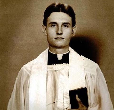 Chaplain (Capt.) Emil J. Kapaun poses for a photo in liturgical dress, holding a bible. (Courtesy photo - U.S. Army)