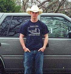 Staff Sergeant Robert Miller in cowboy hat in front of a truck.