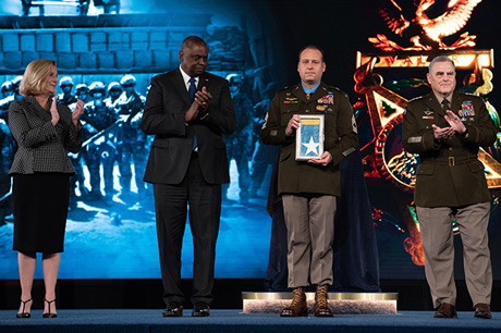 Secretary of the U.S. Army Christine E. Wormuth, Secretary of Defense Lloyd J. Austin III and Chairman of the Joint Chiefs of Staff U.S. Army Gen. Mark A. Milley present the Medal of Honor flag to U.S. Army Master Sgt. Earl D. Plumlee during a Medal of Honor Induction Ceremony at Joint Base Myer-Henderson Hall, Va., Dec. 17, 2021. Master Sgt. Plumlee was awarded the Medal of Honor for actions of valor during Operation Enduring Freedom while serving as a weapon’s sergeant with Charlie Company, 4th Battalion, 1st Special Forces Group (Airborne), near Ghazni, Afghanistan, Aug. 28, 2013. (U.S. Army photo by Laura Buchta)