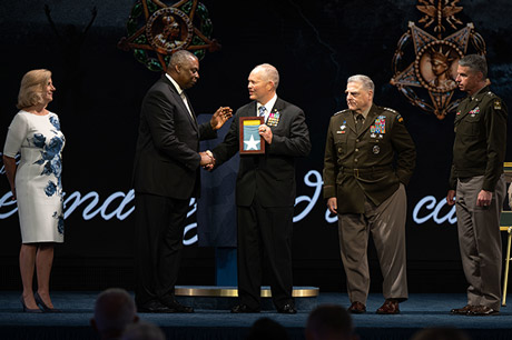 Secretary of Defense Lloyd J. Austin III presents the Medal of Honor flag to retired Army Lt. Col. John D. Lock, accepting on behalf of Medal of Honor recipient Army 1st Lt. Ralph Puckett, Jr., in a ceremony in which Puckett and five other Medal of Honor recipients were inducted into the Pentagon Hall of Heroes, at Joint Base Myer-Henderson Hall, Va., July 6, 2022. (DoD photo by U.S. Navy Petty Officer 2nd Class Alexander Kubitza) 