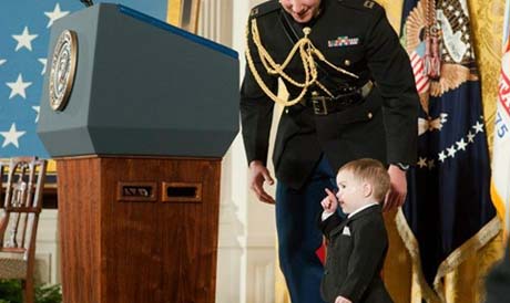 Colin Romesha, son of former Staff Sgt. Clinton Romesha, is gently escorted off the Presidents podium during the Medal of Honor Ceremony. February 11, 2013. (Photo Credit: U.S. Army)