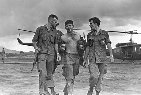 U.S. Army Sgt. Gary M. Rose is helped from a helicopter landing area after Operation Tailwind, 1970. Photo courtesy of Ted Wicorek.
