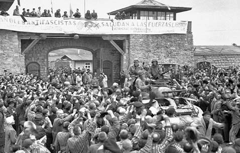  An M8 Greyhound armored car of the US Army's 11th Armored Division entering the Mauthausen concentration camp. The banner in the background (in Spanish) reads as : Anti-fascist Spaniards salute the forces of liberation. Photo courtesy of National Archives and Records Administration.
