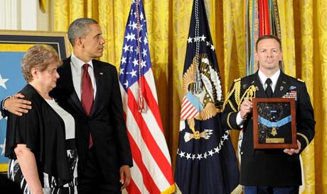 President Barack Obama comforts Rose Buccelli, Specialist 4 Leslie H. Sabo Jr.'s widow, during the White House Medal of Honor Ceremony, posthumously, in honor of Sabo. Then 22-year-old Sabo was killed in action in Cambodia in 1970 while saving the lives of his fellow soldiers in Washington, May 16, 2012.