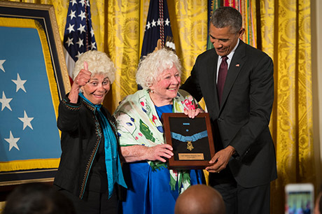 President Barack Obama bestows the Medal of Honor to Sgt. William Shemin, accepting on his behalf are his daughters, Elsie Shemin-Roth (middle) and Ina Bass (left), in the East Room of the White House, June 2, 2015. Shemin, a Jewish-American, distinguished himself as a member of 2nd Battalion, 47th Infantry Regiment, 4th Infantry Division, American Expeditionary Forces, during combat operations against the enemy on the Vesle River, near Bazoches, France, during World War I. While serving as a rifleman from August 7-9, 1918, Shemin left the cover of his platoon's trench and crossed open space in full sight of the Germans, repeatedly exposing himself to heavy machine gun and rifle fire to rescue the wounded. After officers and senior noncommissioned officers had become casualties, Shemin took command of the platoon and displayed great initiative under fire, until he was wounded, Aug. 9. Shemin was wounded by shrapnel and a machine-gun bullet that pierced his helmet that was lodged behind his left ear, leaving him partially deaf. 
U.S. Army photo by Staff Sgt. Bernardo Fuller