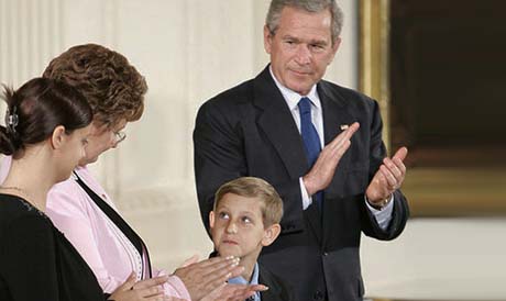 Young David Smith holds his father's Medal of Honor — presented by President Bush — as he looks to his mother, Birgit Smith, during ceremonies Monday, April 4, 2005, at the White House. Sgt. 1st Class Paul Smith, was mortally wounded while saving other members of his task force during Operation Iraqi Freedom.Courtesy George Bush Whitehouse Archives. Photo by Paul Morse.
