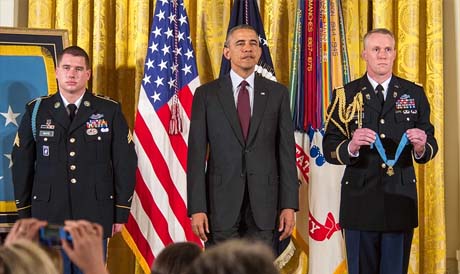 Former Army Sgt. Kyle J. White and President Barack Obama listen to the reading of the citations during a Medal of Honor ceremony at the White House, Washington. White is being awarded the Medal of Honor for his actions while on a dismounted movement in the mountainous terrain in Aranas, Afghanistan, Nov. 9, 2007. (U.S. Army Photo by Sgt. Mikki L. Sprenkle/Released)