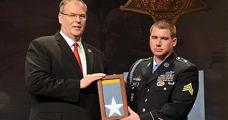 Former Army Sgt. Kyle J. White receives an encased Medal of Honor flag, as he is inducted into the Pentagon Hall of Heroes, May 14, 2014, one day after receiving the Medal of Honor for actions in Afghanistan during the Battle of Aranas on Nov. 9, 2007. Pictured with White is Deputy Secretary of Defense Robert O. Work. (Army News Service photo by Lisa Ferdinando)