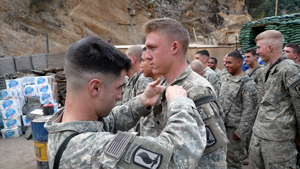 1st Lt. Matthew C. Ferrara awards Spc. Kain Schilling the Combat Infantryman Badge, during a ceremony in Nuristan Province, Afghanistan, Nov. 6, 2007. The CIB is awarded to Infantry or Special Forces Soldiers who actively engage in ground combat with...