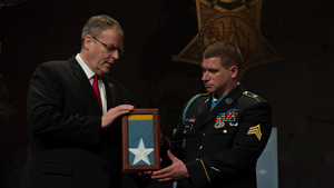 Deputy Defense Secretary Bob Work presents the Medal of Honor flag to former Army Sgt. Kyle J. White, the most recent Medal of Honor recipient, during a ceremony to induct White into the Hall of Heroes at the Pentagon, May 14, 2014. President Barack ...