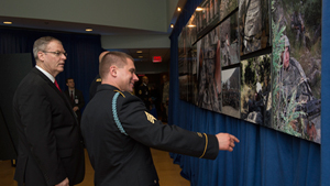 Deputy Defense Secretary Bob Work listens as former Sgt. Kyle White, the most recent Medal of Honor recipient, discusses some photos of him at the Pentagon, May 14, 2014. Work presided over a ceremony to induct White into the Pentagon's Hall of Heroe...