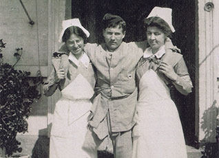 Two Army nurses assisting an amputee