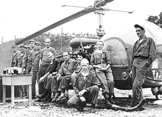 Army female nurses stand around a helicopter in Korea during the Korean War