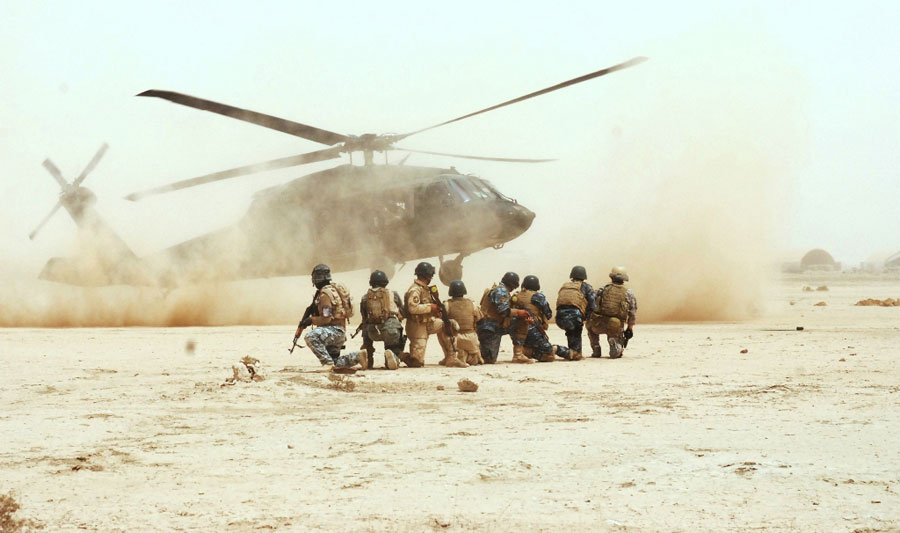 Commandos and Tactical Security Unit personnel watch UH-60 Black Hawk