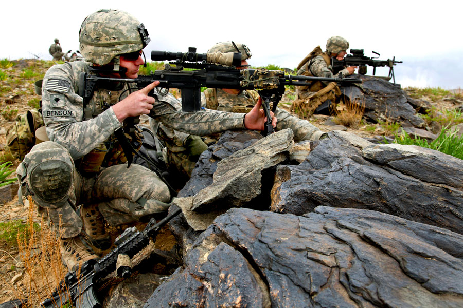 Soldiers with sniper rifle provide security as convoy passes